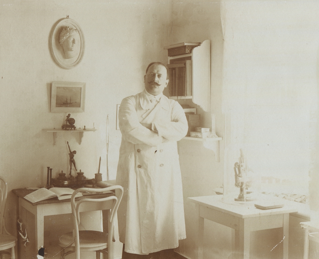 Ārsts Vladimirs Kuharenko (1873-1939) savā darba kabinetā, tērpies baltā halātā